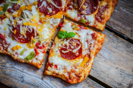 Naklejki Square pepperoni pizza on rustic wooden background