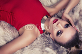 Fototapety beautiful woman in red dress lying on fur