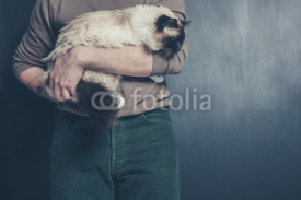 Naklejki Young man holding a big cat