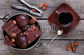 Naklejki Chocolate in a metal vase, coffee and nuts on a gray wooden back
