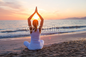 Naklejki Caucasian woman practicing yoga at seashore