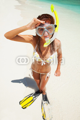Fun woman with snorkeling equipment on the beach