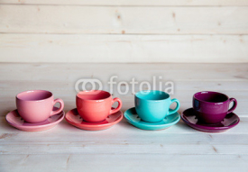 Colorful coffee cups on wooden table