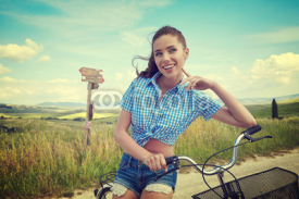Sexy woman with vintage bike in a country road.