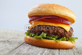Obrazy i plakaty Grilled hamburger on wooden board