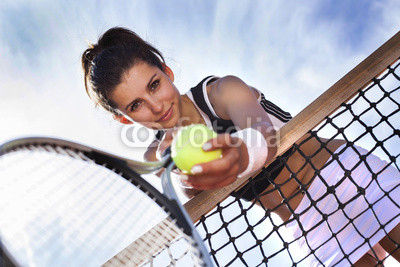 Beautiful young girl rests on a tennis net