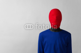 Fototapety Surrealism Theme: man in a blue jacket with a red cloth tied around his head is in the corner on a gray background