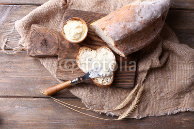 Fresh bread and homemade butter on wooden background