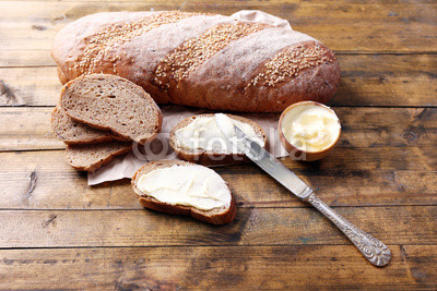 Fresh bread and homemade butter on wooden background