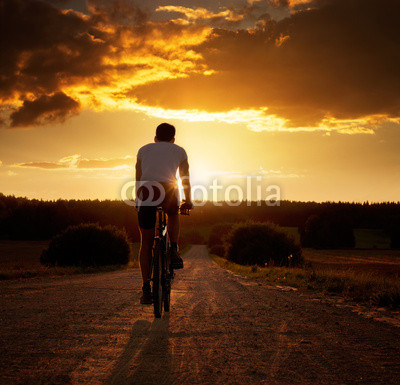 Man Riding a Bicycle at Sunset