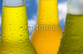 Fototapety Three wet bottles with a sky in the background