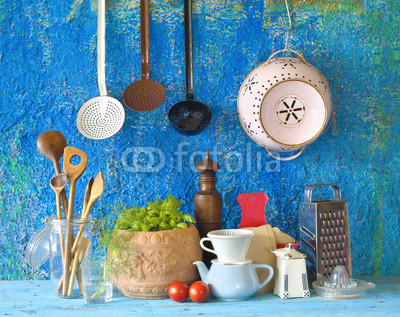 various vintage kitchen utensils,against blue wall