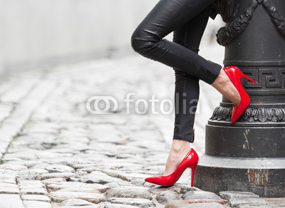 Sexy legs in black leather pants and red high heel shoes
