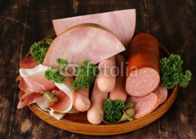 Naklejki various kinds of sausages and smoked bacon on the wooden plate