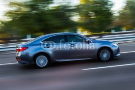Obrazy i plakaty A modern sports car speeding along the road with a motion blur