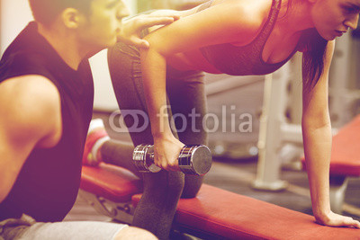 close up of couple with dumbbell exercising in gym