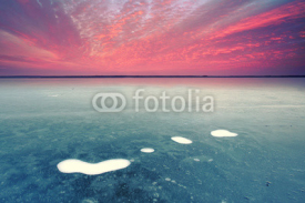 Obrazy i plakaty frostig zugefrorener See mit Luftblasen zum Sonnenuntergang