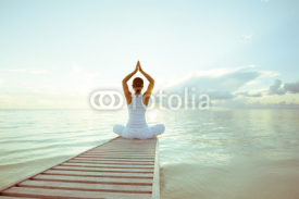 Fototapety Caucasian woman practicing yoga at seashore