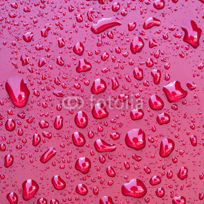 Crystal clear water drops over red background