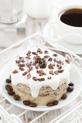 coffee cake with icing decorated with cocoa beans, top view
