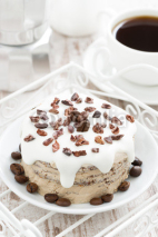 Naklejki coffee cake with icing decorated with cocoa beans, top view