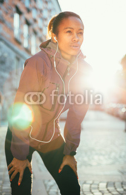 Tired young woman catching breath after a long run in city