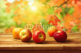 Apples on woodn table over autumn bokeh background