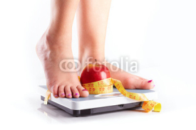 Obrazy i plakaty A pair of female feet standing on a bathroom scale with red appl
