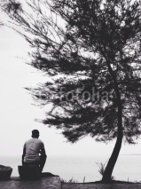 Fototapety man sitting on the beach
