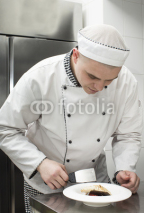 Naklejki chef preparing food in the kitchen at the restaurant