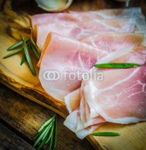 Fototapety Prosciutto with garlic and rosemary on rustic wooden background