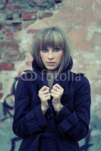 Fototapety Young blonde posing against aged brick wall