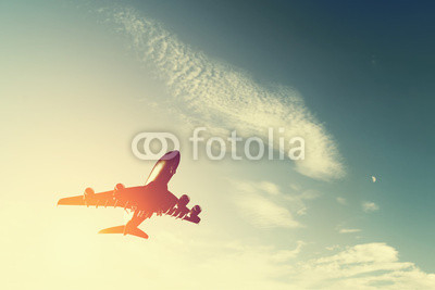 Airplane taking off at sunset. Silhouette of a flying aircraft