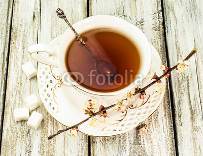 cup of tea with flowering branches apricots