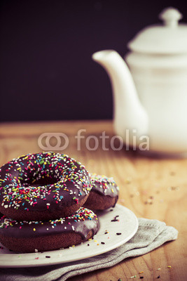 Colorful chocolate donuts and teapot