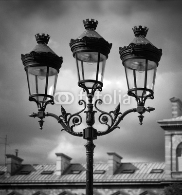 Black and White Image of Lamps Against a Cloudy Sky