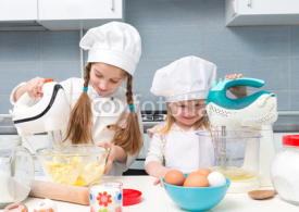 two little girls in chef uniform with ingredients on table