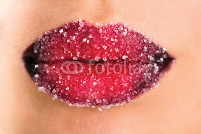 Woman's red lips coated with scattered sugar