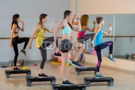 Fototapety Group of women exercising on aerobic stepper