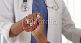 Naklejki Close up of female African American doctor holding patient's hand