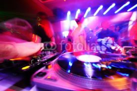 Naklejki DJ behind the decks in a nightclub.