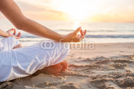 Fototapety Caucasian woman practicing yoga at seashore