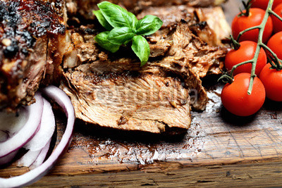 grilled  steak, cherry tomatoes and basil on a cutting board