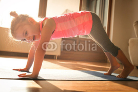 Little girl doing exercise at home.