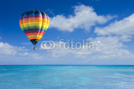 Naklejki Colorful hot air balloon fly over the blue sea