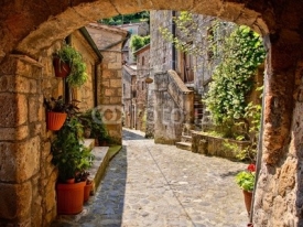 Fototapety Arched cobblestone street in a Tuscan village, Italy