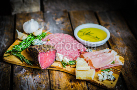 Naklejki Chopping board of Assorted Cured Meats, Cheese and Honey with ro