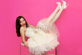 Beautiful girl in white dress having fun on the table