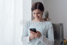 Woman texting in the kitchen