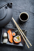 Obrazy i plakaty Fresh sushi served in a black ceramic
